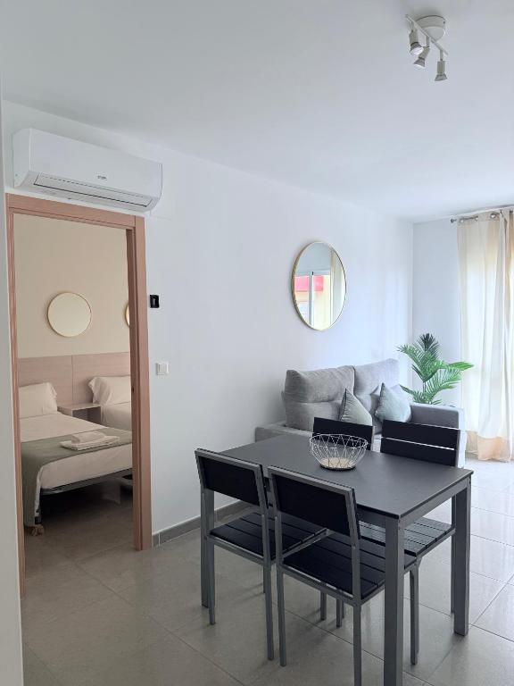 a living room with a table and a couch at Iberflat Apartamentos Marina Suites in Grao de Castellón