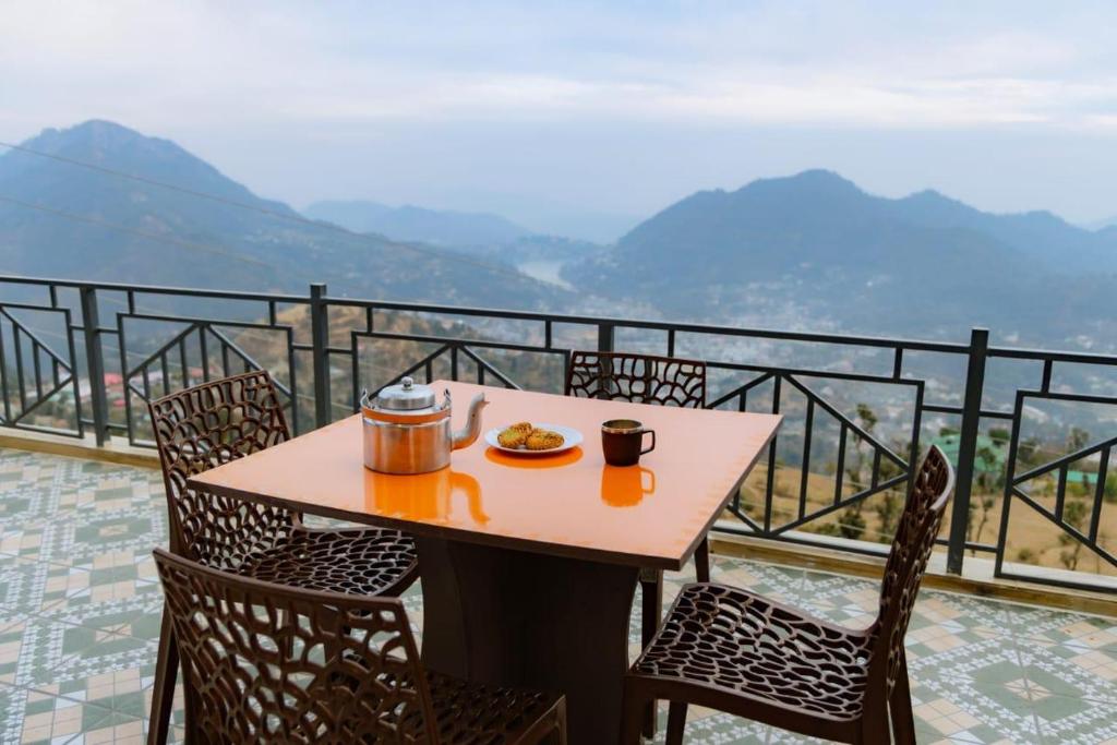 a table with a plate of food on top of a balcony at Baatuli Homestay in Nainital