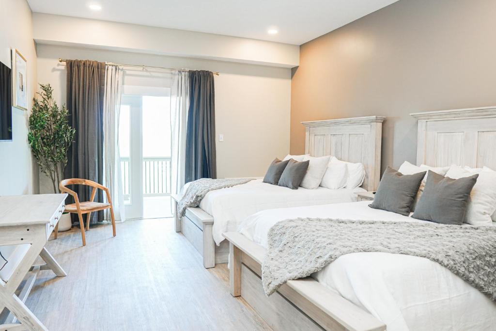 a bedroom with two beds and a desk at Hotel Whiskey in Long Beach in Long Beach