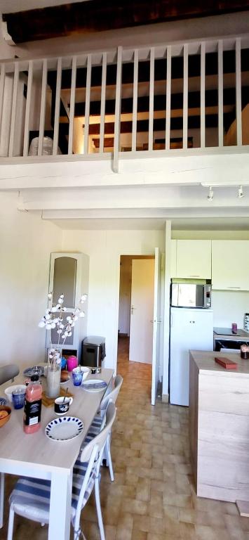 a kitchen and dining room with a table and chairs at Duplex Camargue Village in Le Grau-du-Roi