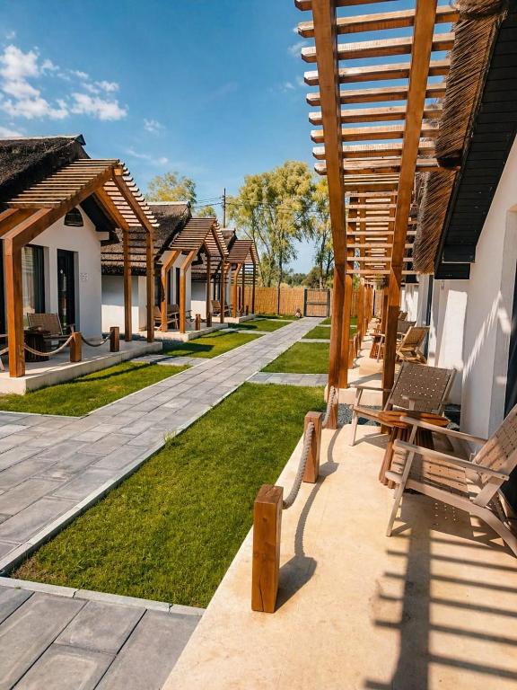 a patio with a row of houses with benches at Danube Delta Bungalows Gorgova in Gorgova