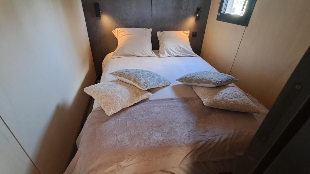 a bed with two pillows on it in a room at Chalet Villerest in Villerest