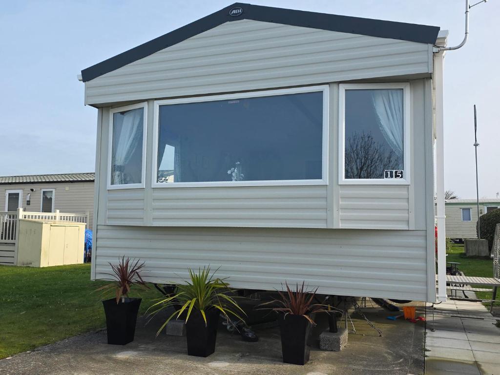 a tiny house with a window in a yard at Pines 15 in Porthcawl