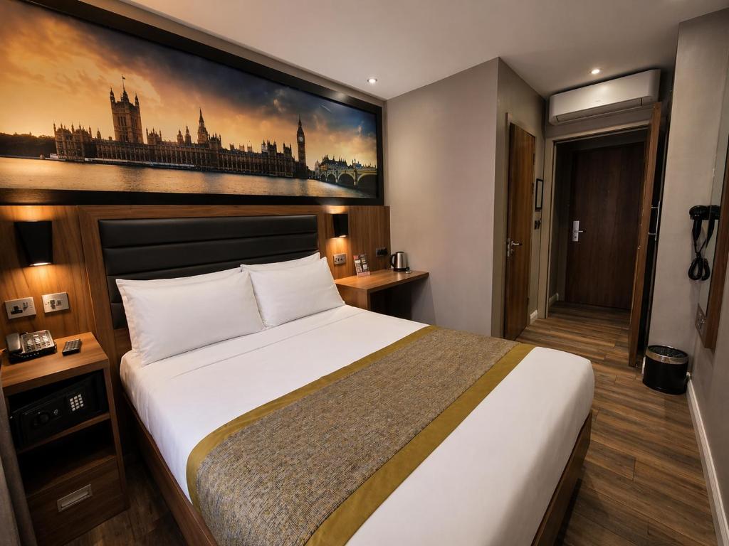 a bedroom with a large bed and a painting on the wall at London Court Hotel in London