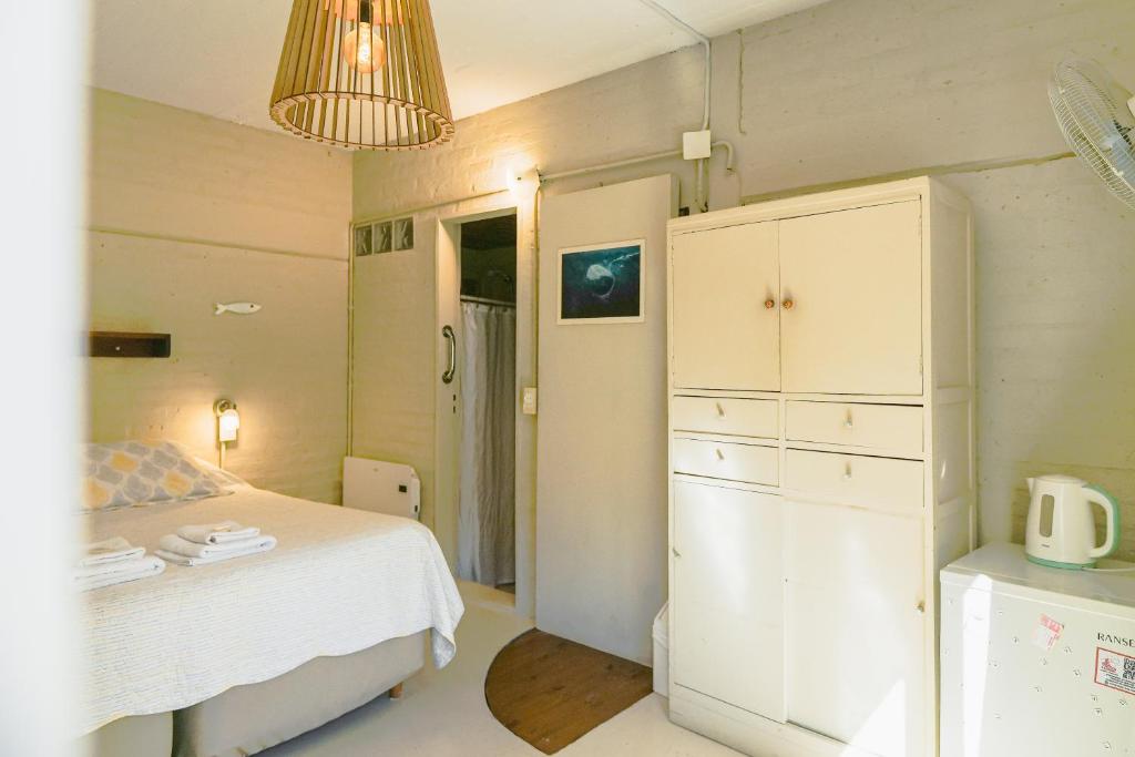 a bedroom with a bed and a white cabinet at De Luna in Puerto Pirámides