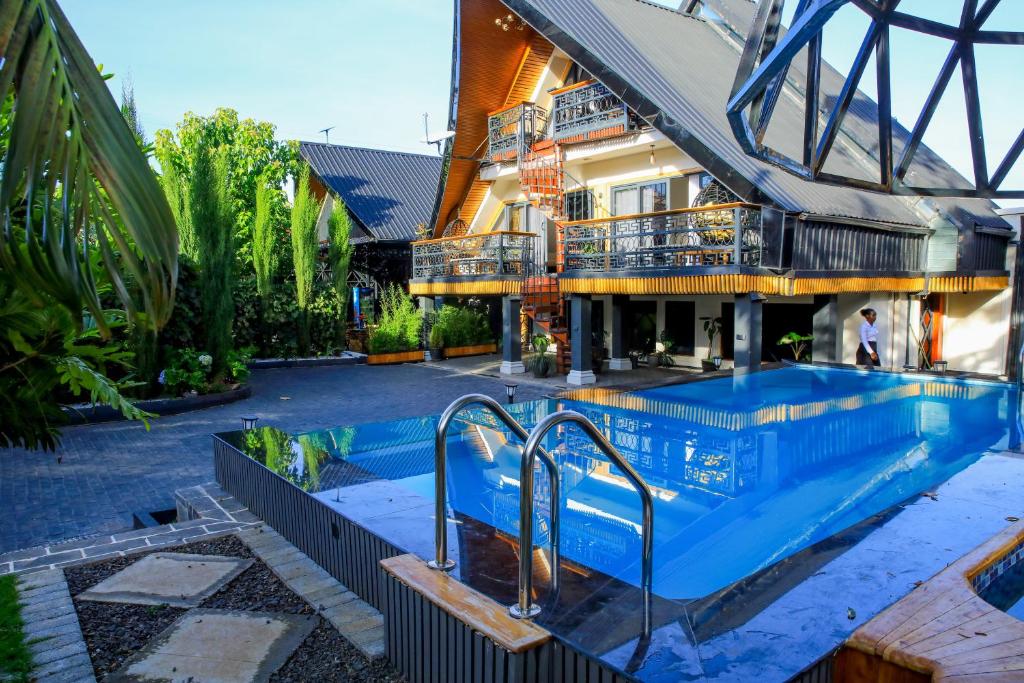 a swimming pool in front of a building at Fortunas Resort Nkubu, Meru in Nkubu