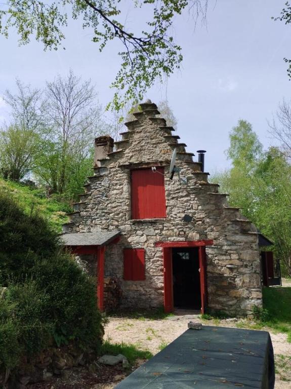 an old stone house with a red door at Grange aménagée in Campan