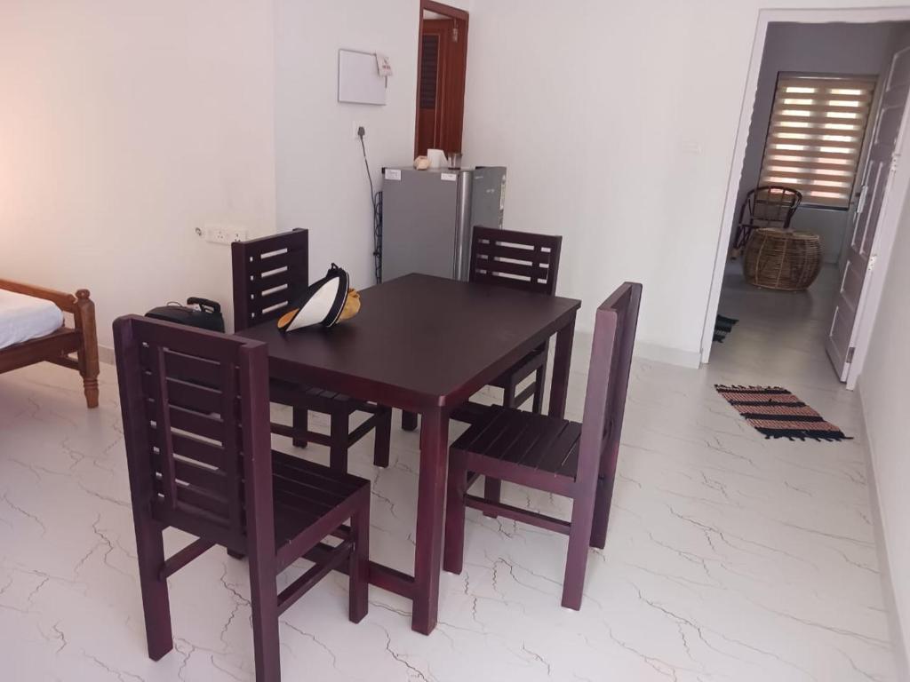 a wooden table and chairs in a room at 1BR Nest in Varkala
