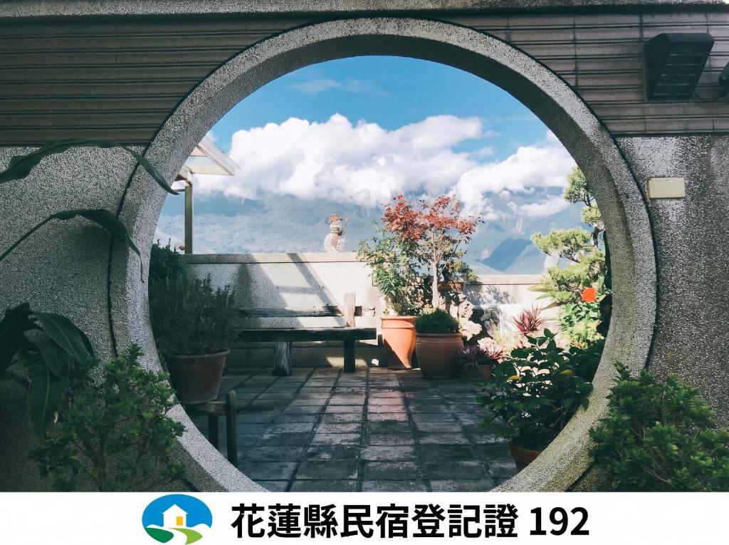 a circular window with a view of a patio at Ho Feng Private Hotel 電梯自助民宿 in Ji'an