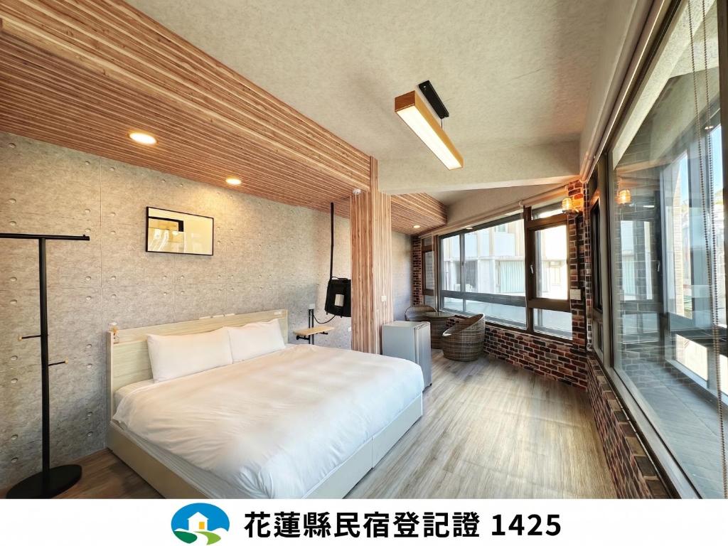 a bedroom with a bed and a large window at 達魯瑪民宿 Daluma -無停車位 in Hualien City