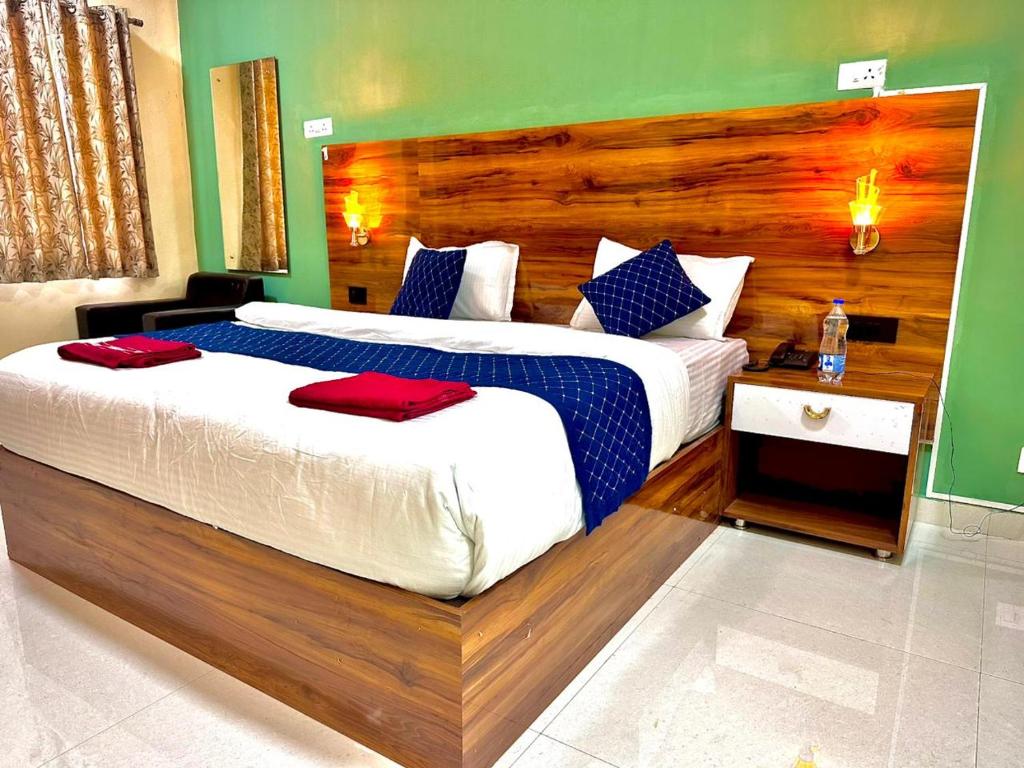 a bedroom with a large bed with a wooden headboard at IRCTC Hotel HOSPET in Hospet