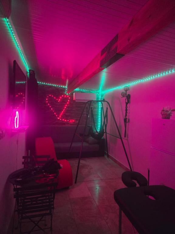 a room with pink and green lights in a room at love room les plaisirs partagés in Arles