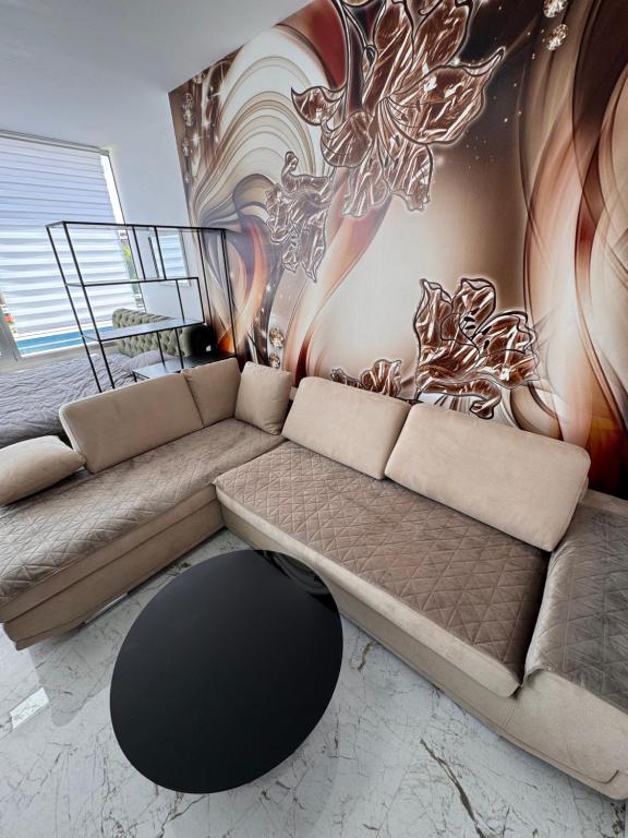 a living room with a couch and a mural at Apartman CITY CENTER 9 BAZEN in Prijedor