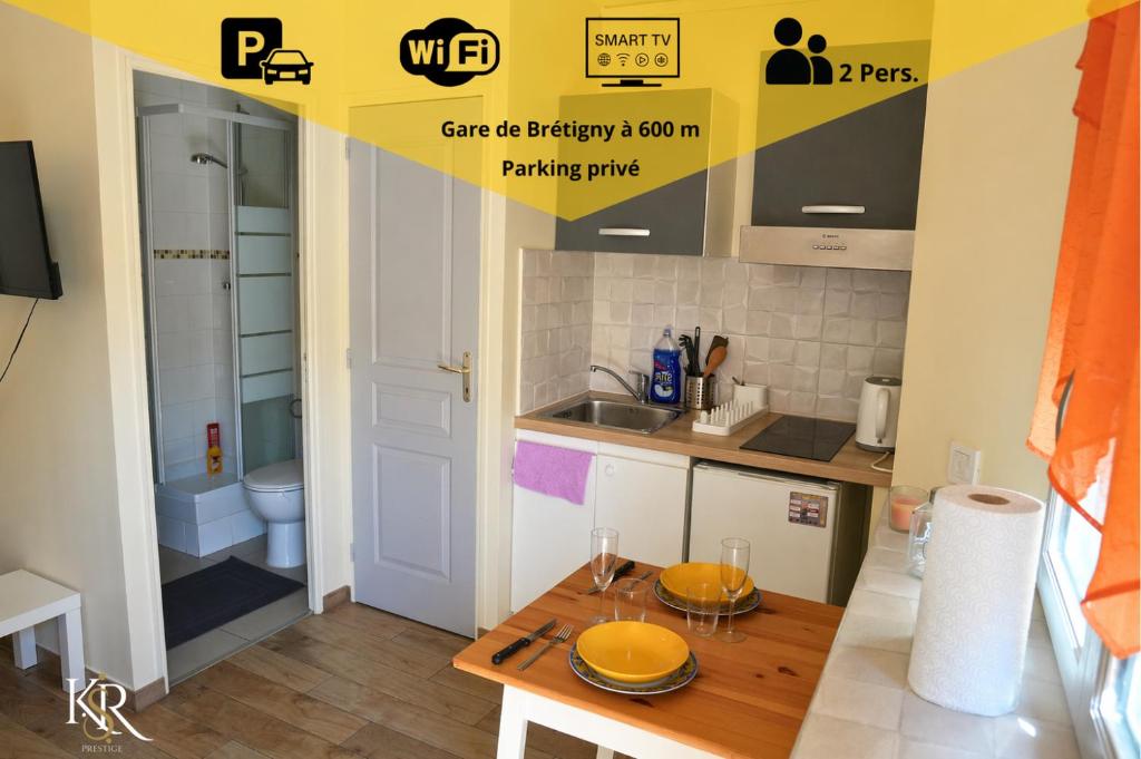 a kitchen with a table and a sink and a toilet at Studio cosy & bien équipé in Brétigny-sur-Orge
