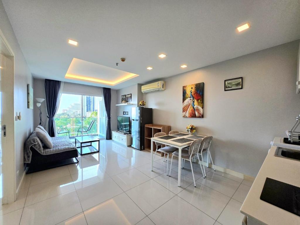 a kitchen and living room with a table and chairs at One Tower 84 by ThaiminatorPattaya in Pattaya South