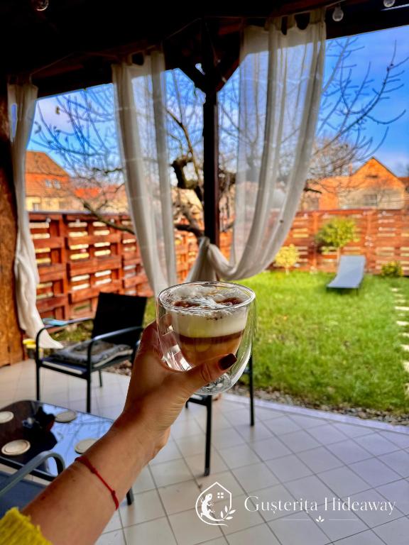a person holding a glass of beer on a patio at Gusterita Hideaway in Sibiu