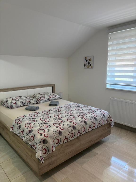 a bedroom with a bed with a comforter and pillows at Apartman Diamond LUX in Surčin