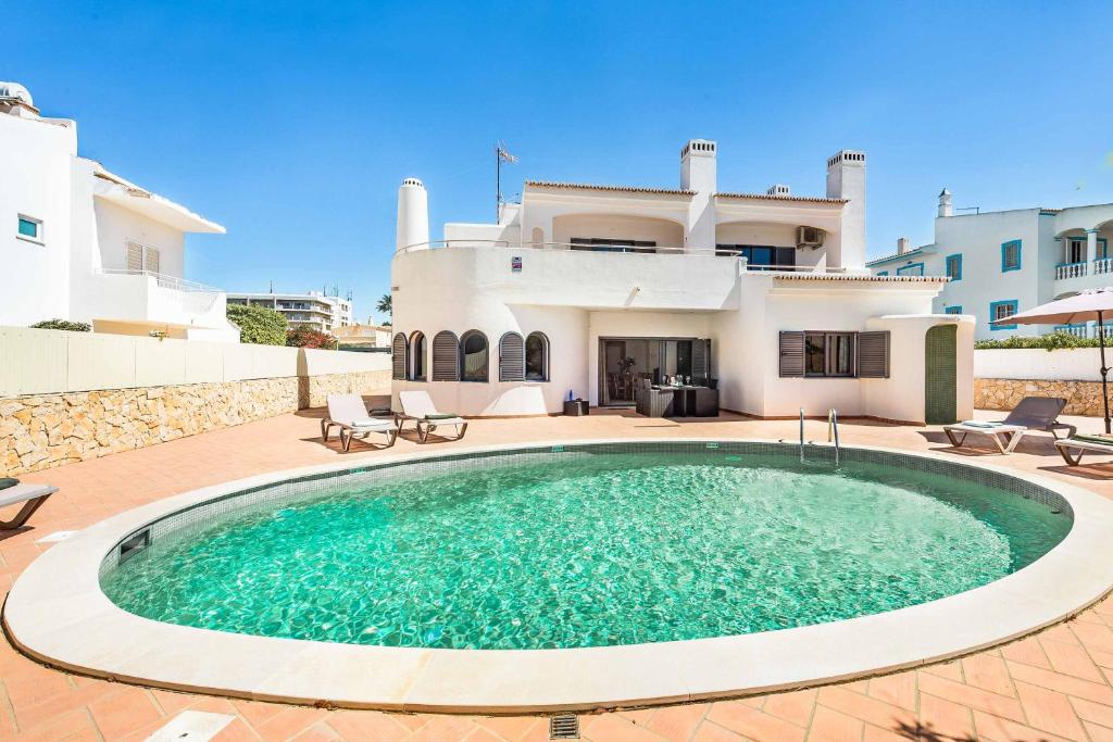a swimming pool in front of a house at Villa Vivienda Jade in Galé