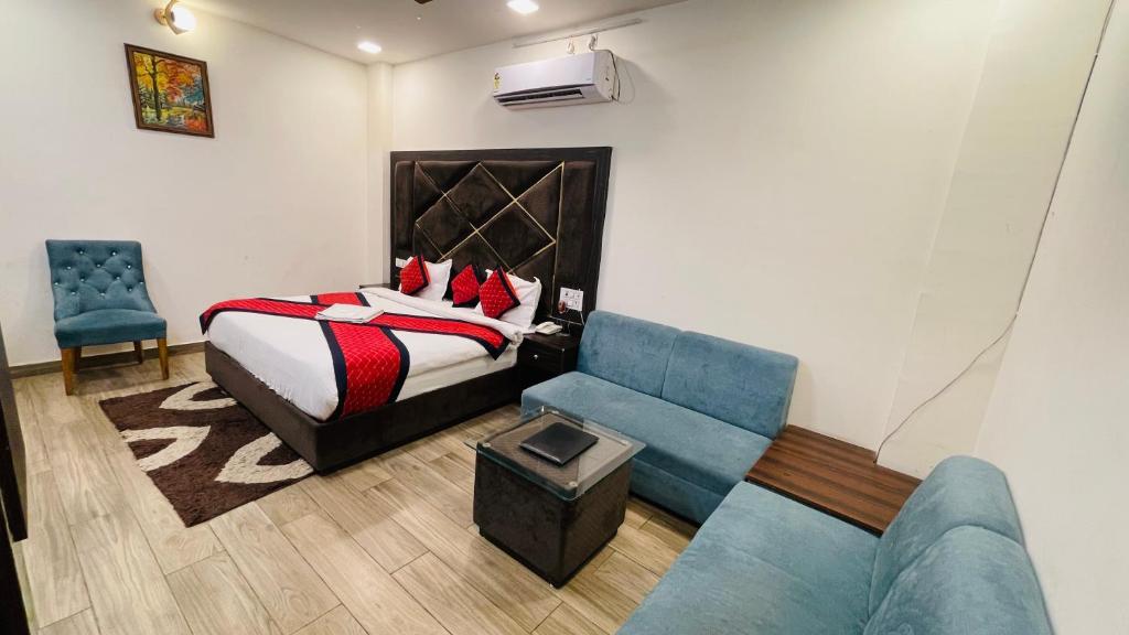 a hotel room with a bed and a blue couch at Vantara Premium, Haridwar- with swimming Pool in Haridwār