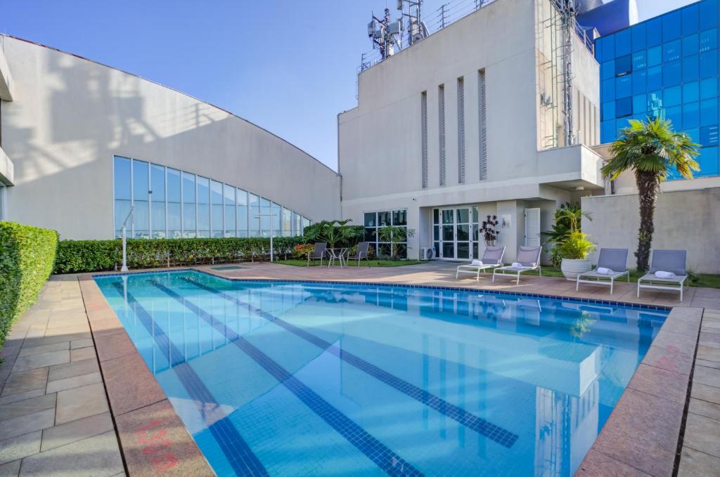 a swimming pool in front of a building at Comfort Ibirapuera in São Paulo