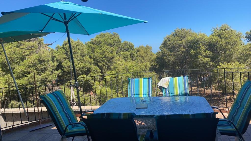 a table with chairs and an umbrella on a deck at villa larhat vue sur mer in Larhat