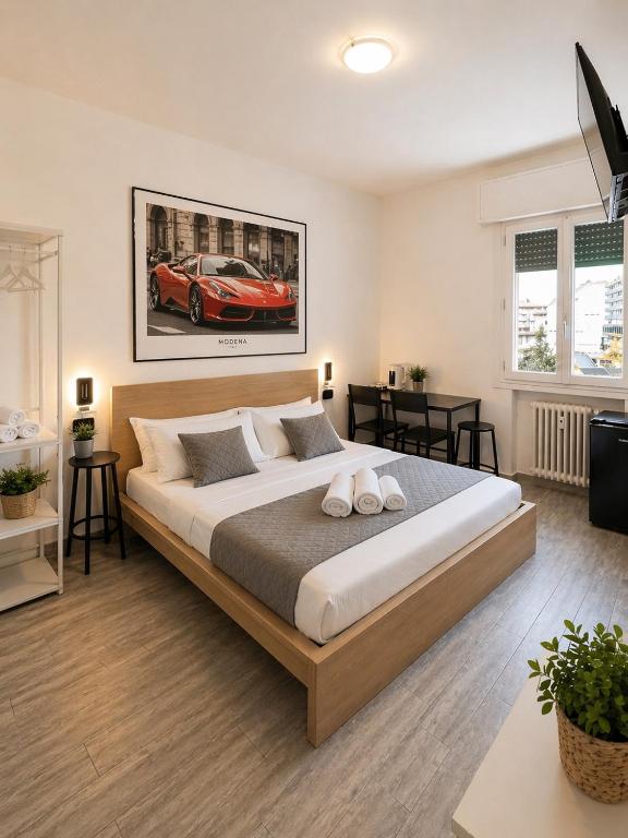 a bedroom with a large bed with a red car on the wall at Modena Station - Suite H24 in Modena