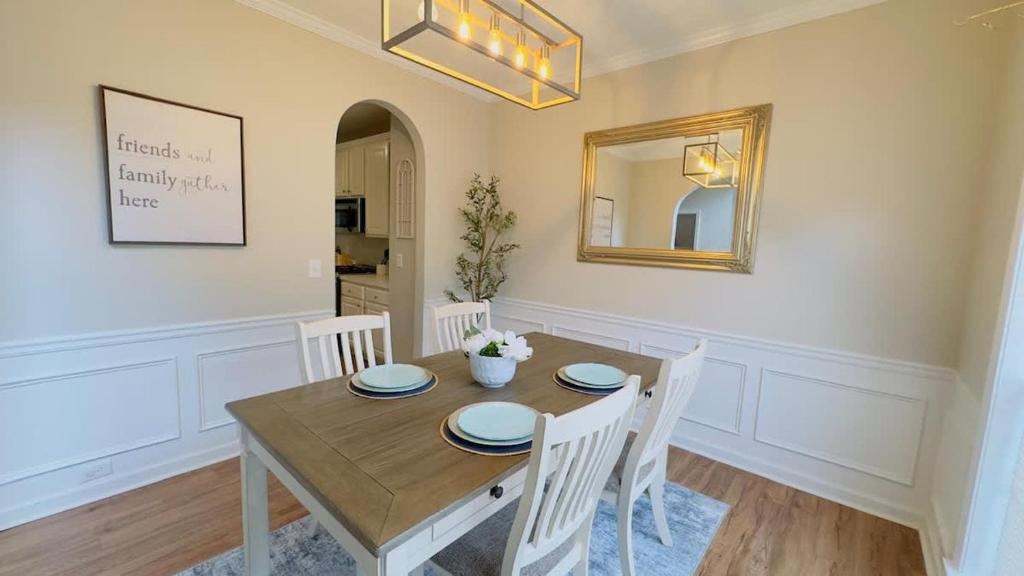 a dining room with a wooden table and white chairs at Dalby Way in Austell