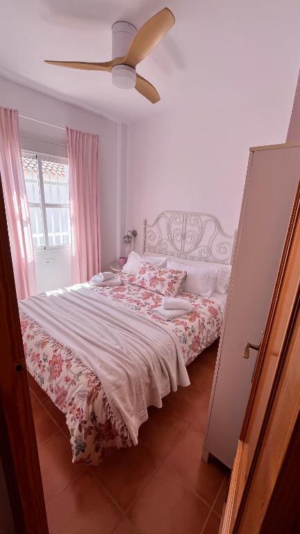 a bedroom with a bed and a ceiling fan at Casa adosada en Urbasur ISLANTILLA in Islantilla
