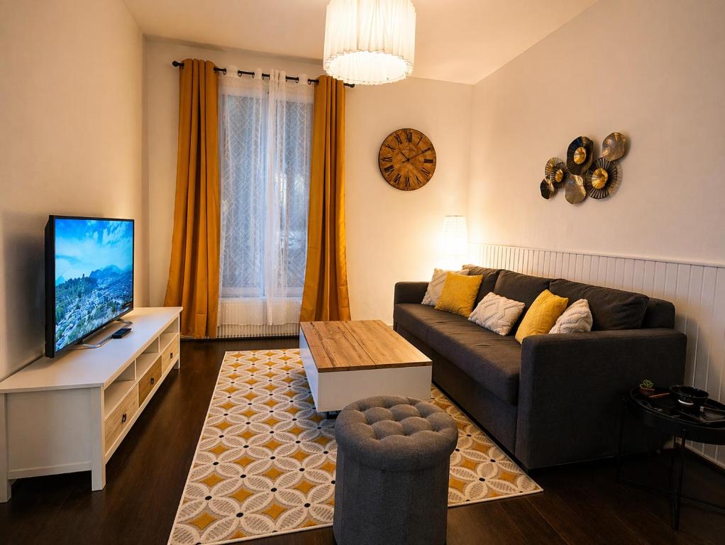 a living room with a couch and a flat screen tv at Appartement 2 pieces cosy proche Paris et metro wifi rapide arrivee autonome in Asnières-sur-Seine