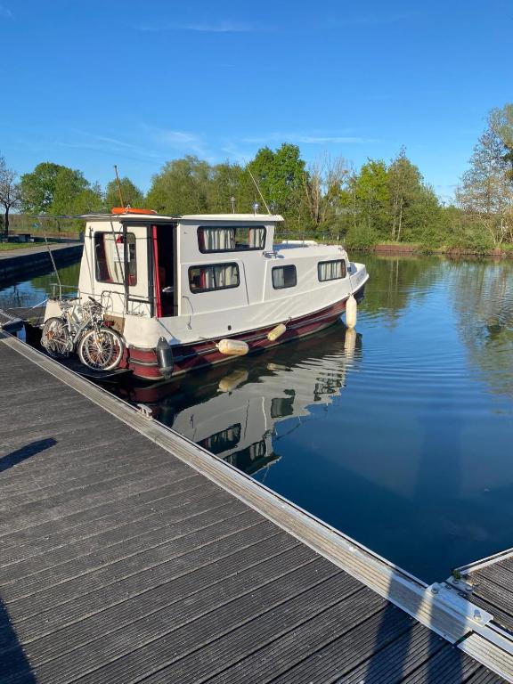 a boat parked next to a dock on the water at Peniche Maryjeanne in Gannay-sur-Loire