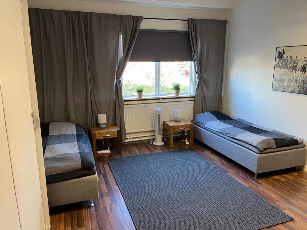 a small room with two beds and a window at Trevlig lägenhet centralt i Kumla in Kumla