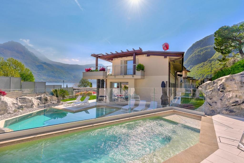 a house with a swimming pool with mountains in the background at Villa Orchidea in Onno