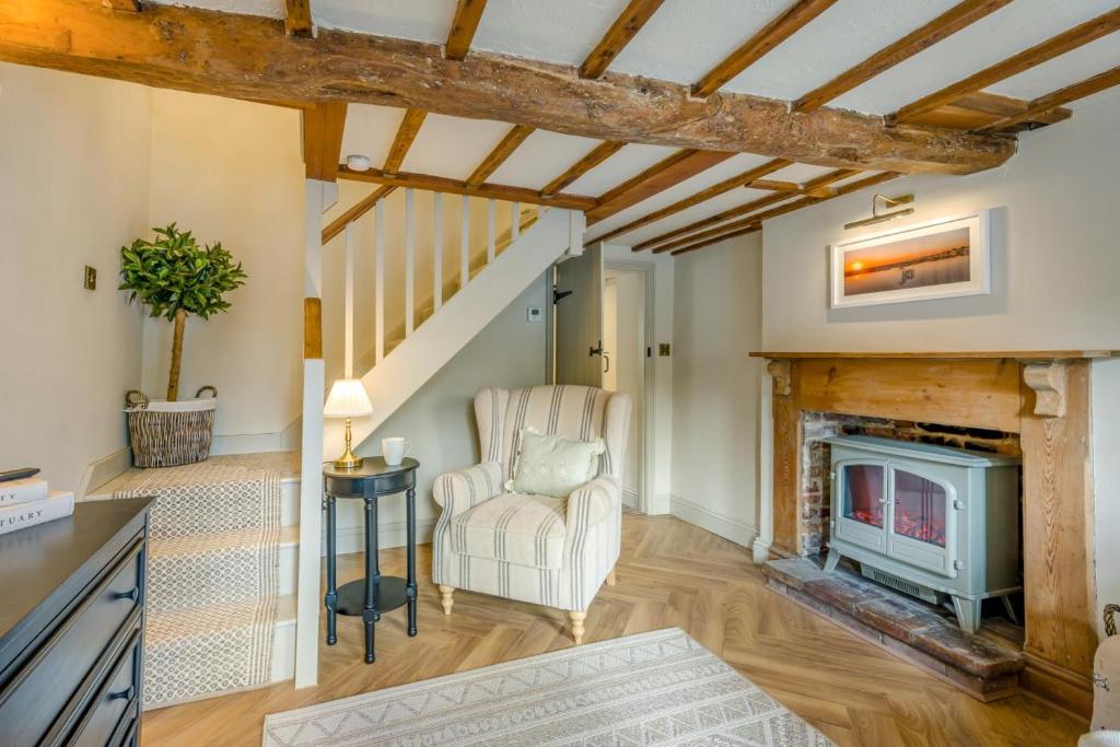 a living room with a fireplace and a chair at 1 Bed in Holt oc-p34797 in Holt