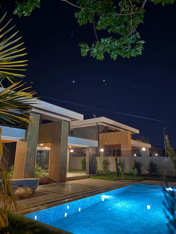 a house with a swimming pool at night at Albera Villas in Kemer