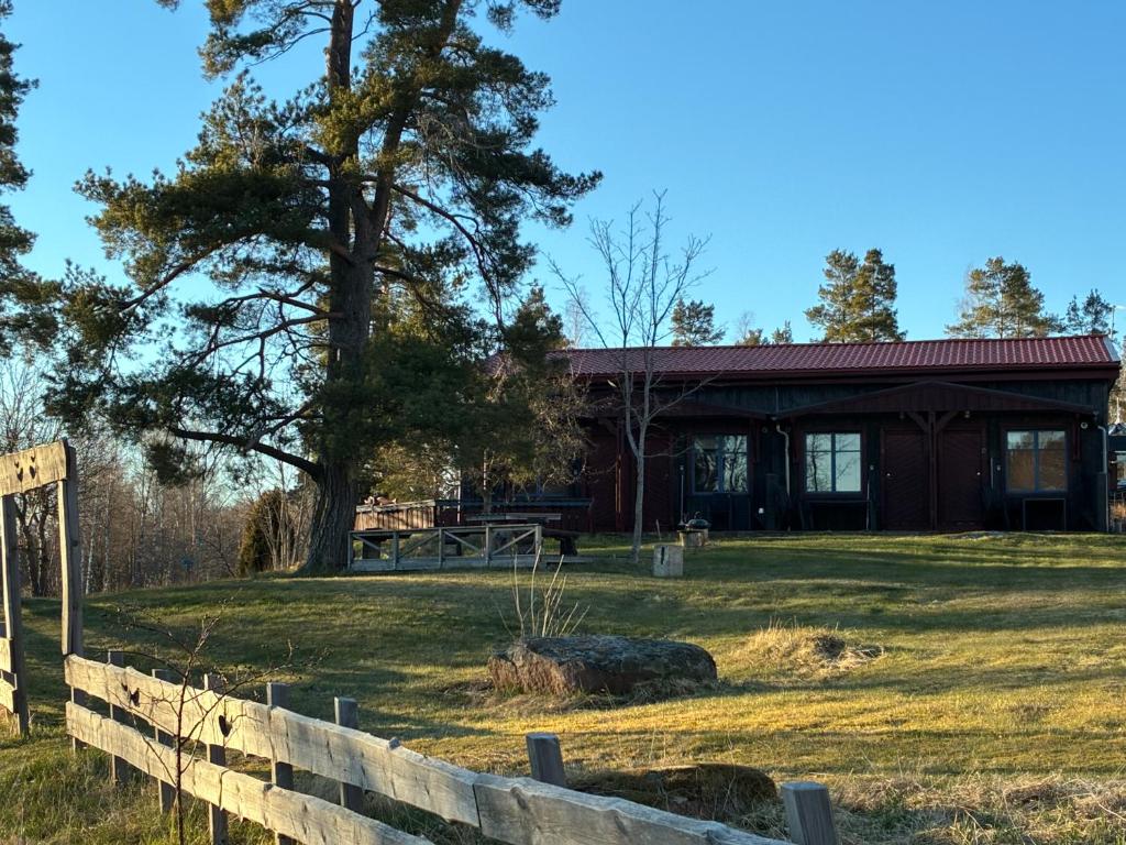a building with a fence in front of a yard at Runneröd in Saltvik