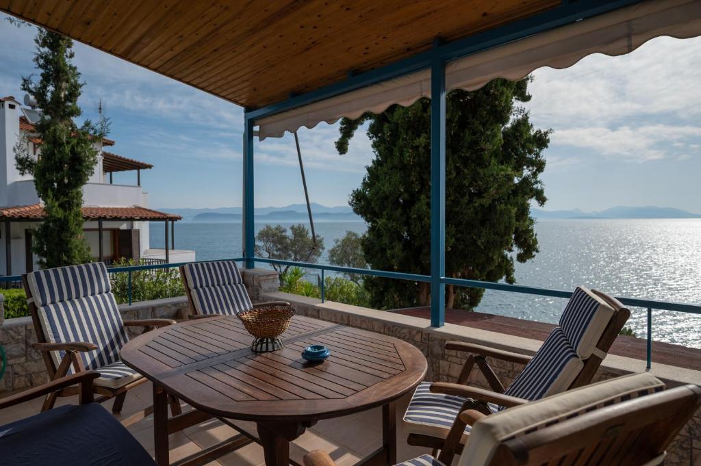 a table and chairs on a deck with a view of the water at Xiro Retreat in Xiropigado