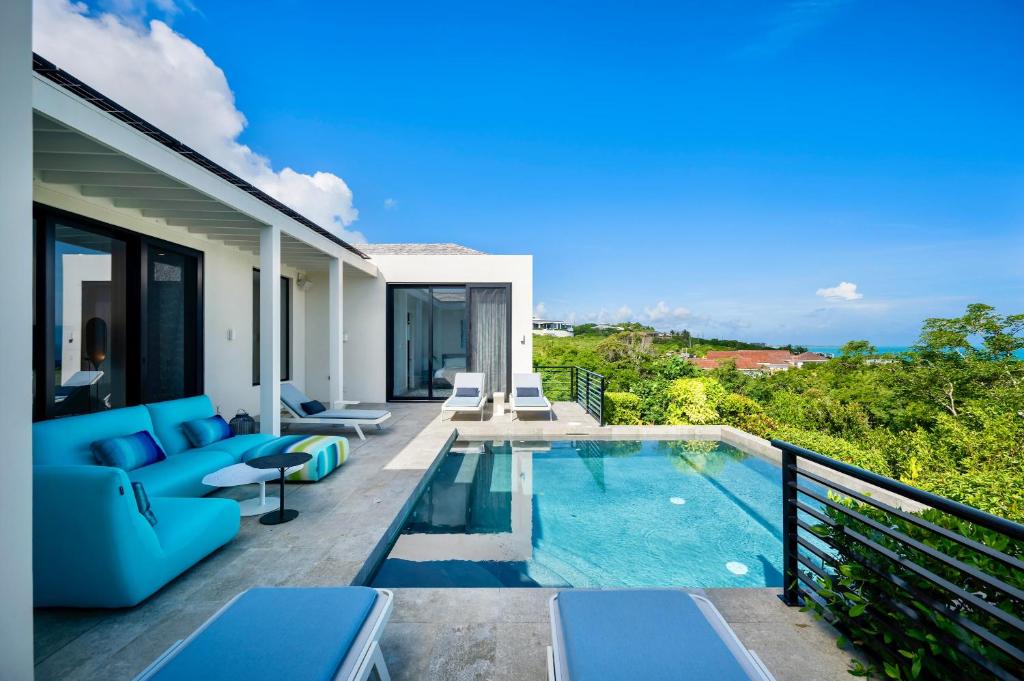 a villa with a swimming pool on a balcony at Skyline Villas - Villa Pluto Oceanfront with Private Pool in Providenciales