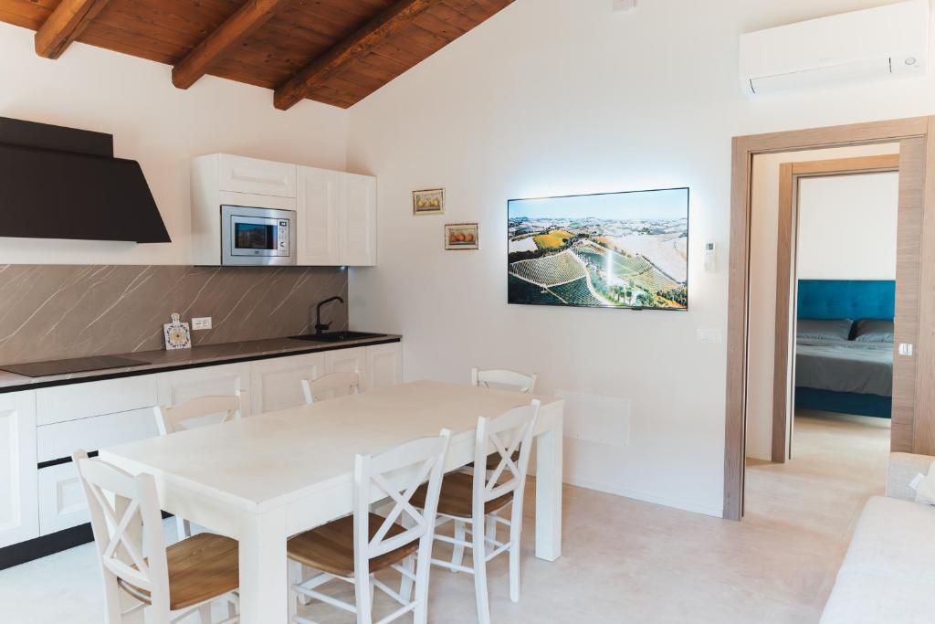 a kitchen and dining room with a white table and chairs at Villa Codetta Chalet Caterina in Boccatossa