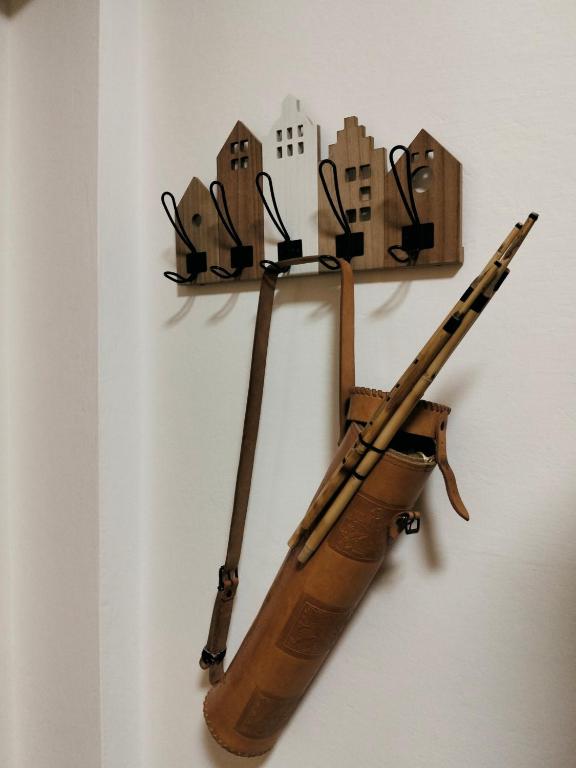 eine hölzerne Geige hängt an einer Wand mit Gebäuden in der Unterkunft Armoniasdecanna in Monastir