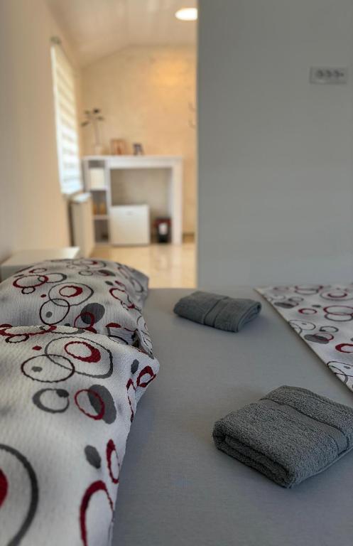 a bed with pillows on it in a room at Apartman Gold LUX in Surčin