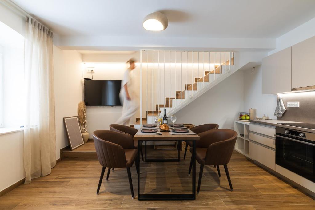 a kitchen with a table and chairs and a staircase at Amare in Mali Lošinj