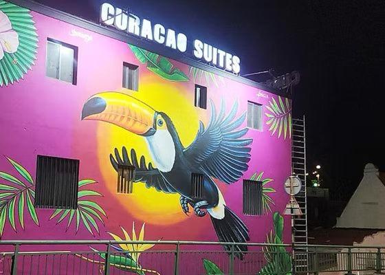 a building with a painting of a toucan on it at Curacao Suites Hotel in Willemstad
