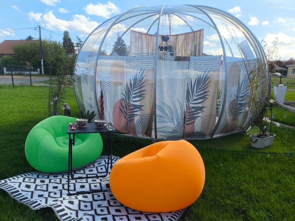 a dome tent with a table and chairs in the grass at Cocoon Reflex'Ô in Escurolles