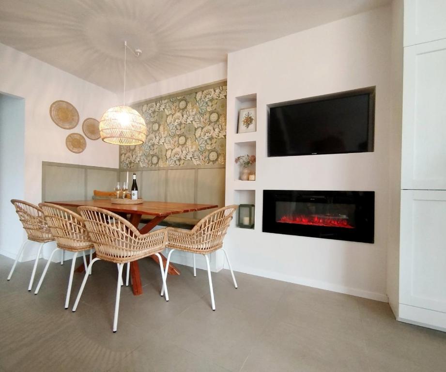 a dining room with a table and chairs and a fireplace at Szederinda házikó in Alsóörs