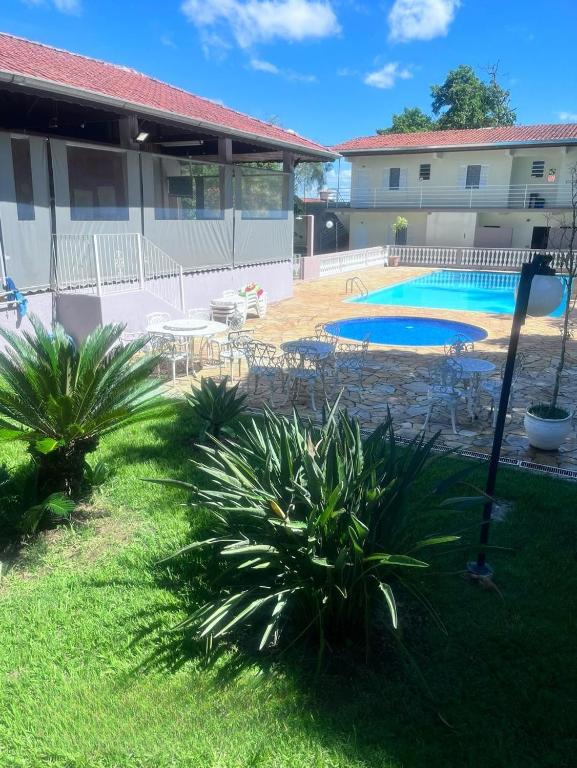 a yard with two palm trees and a swimming pool at Pousada Mais Cacau in Itu
