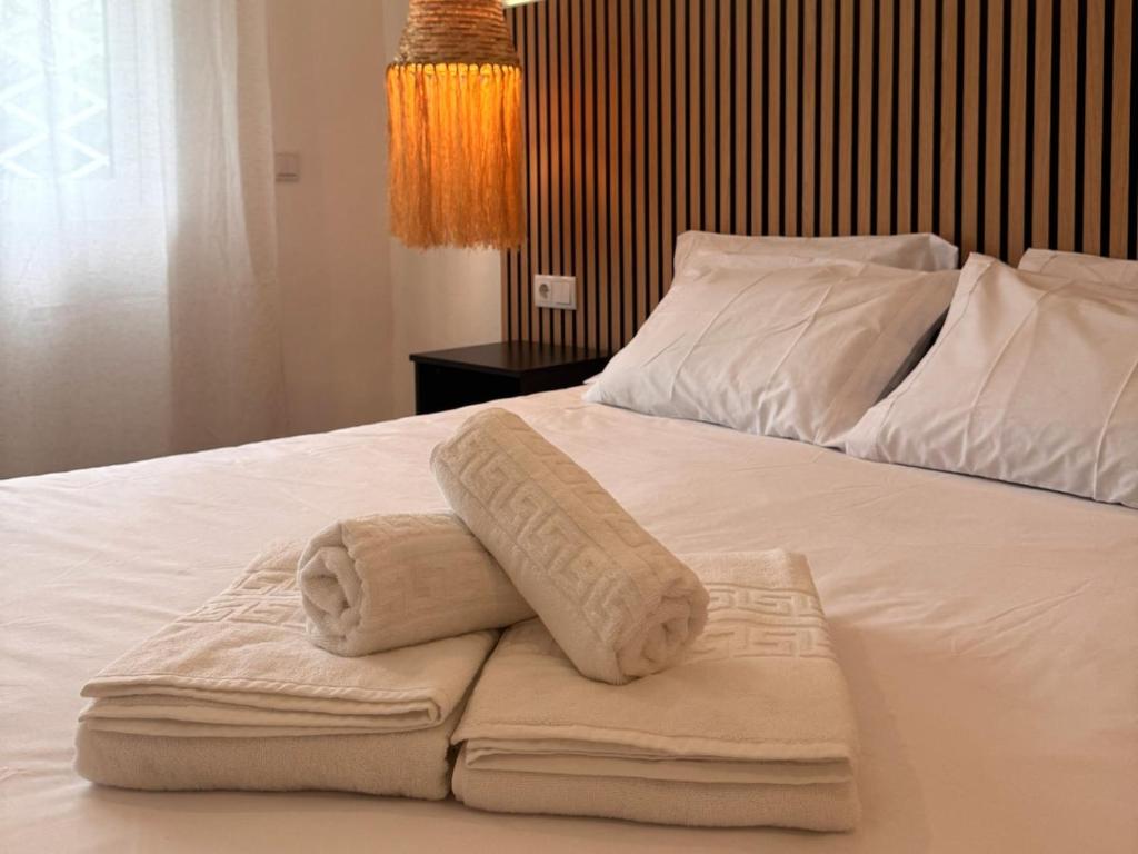 two towels sitting on top of a white bed at Apartmento 3037 in Quarteira