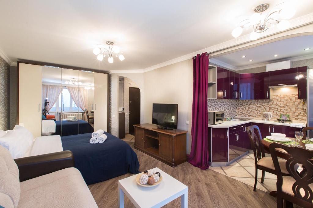 モスクワにあるLux Apartments - Yakimankaのリビングルーム(ベッド1台付)、キッチンが備わります。