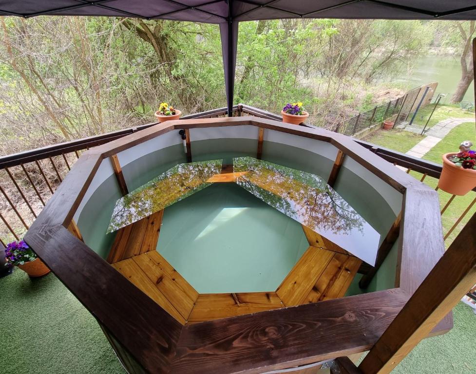 an outdoor plunge pool on a deck with an umbrella at PART II apartman in Tiszaug