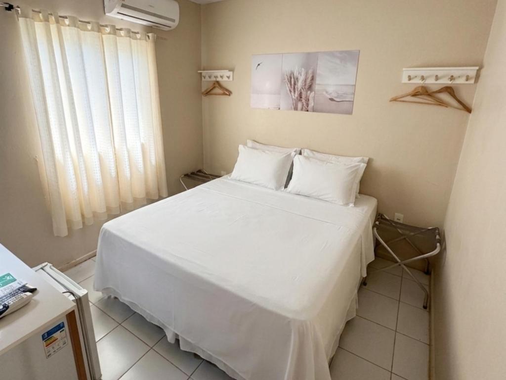 a bedroom with a bed with white sheets and pillows at Casa do Anjo in Fernando de Noronha