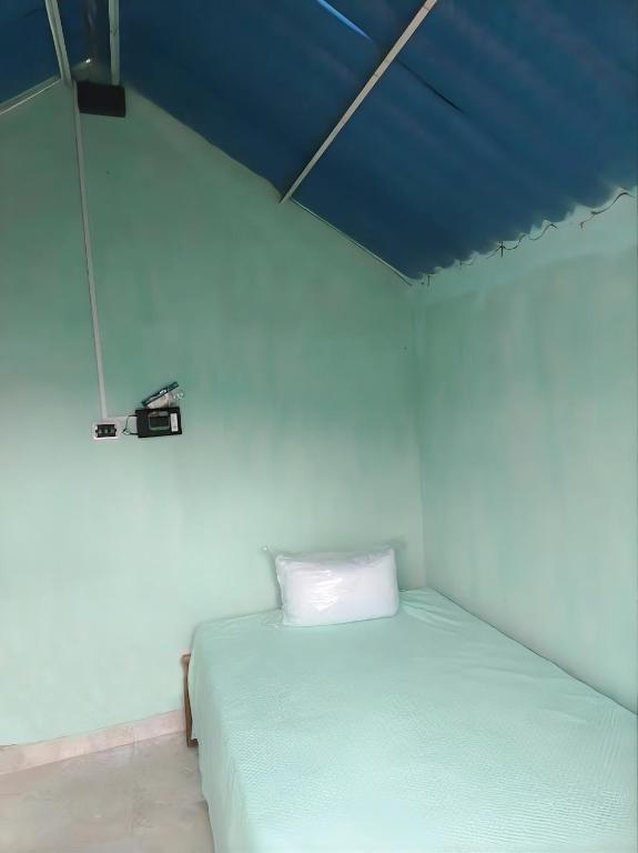 a bed in a room with a blue ceiling at cabañas de descanso in Anolaima